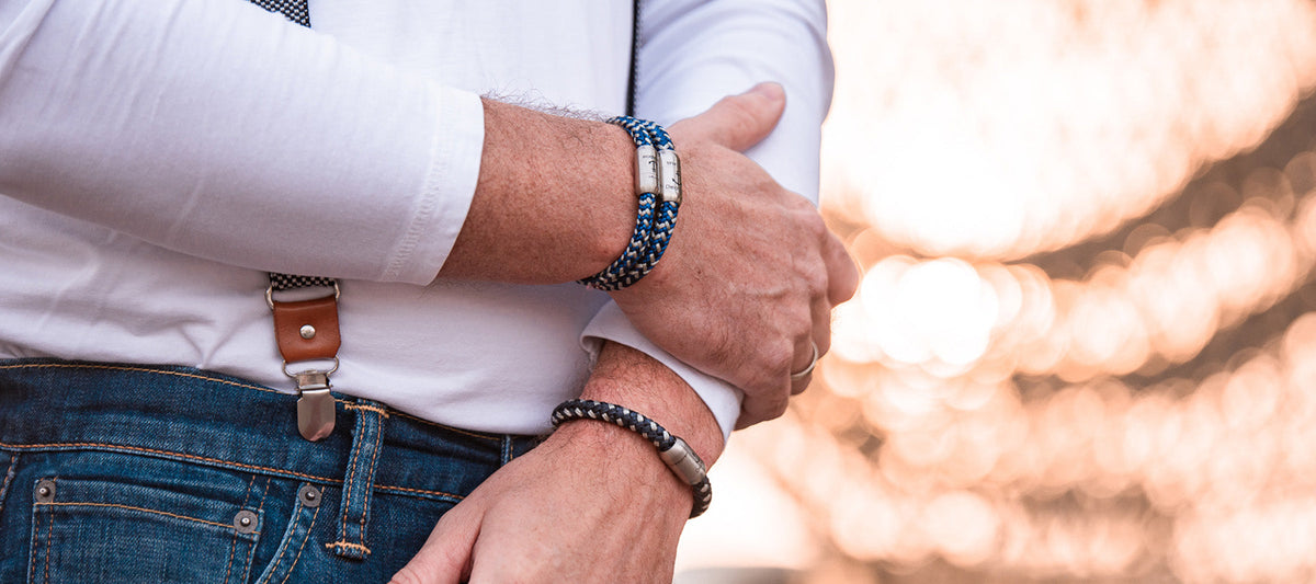 Mann im weißen Hemd mit blauen Segeltau-Armbändern an beiden Handgelenken