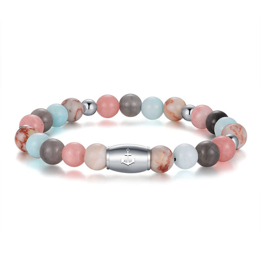The Armband Pellworm features Pink Jade, quartz crystal, red net jasper, and stainless steel beads with a silver clasp engraved with an anchor symbol.