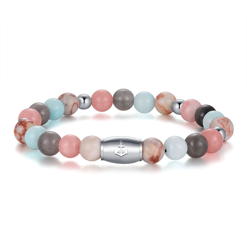 The Armband Pellworm features Pink Jade, quartz crystal, red net jasper, and stainless steel beads with a silver clasp engraved with an anchor symbol.