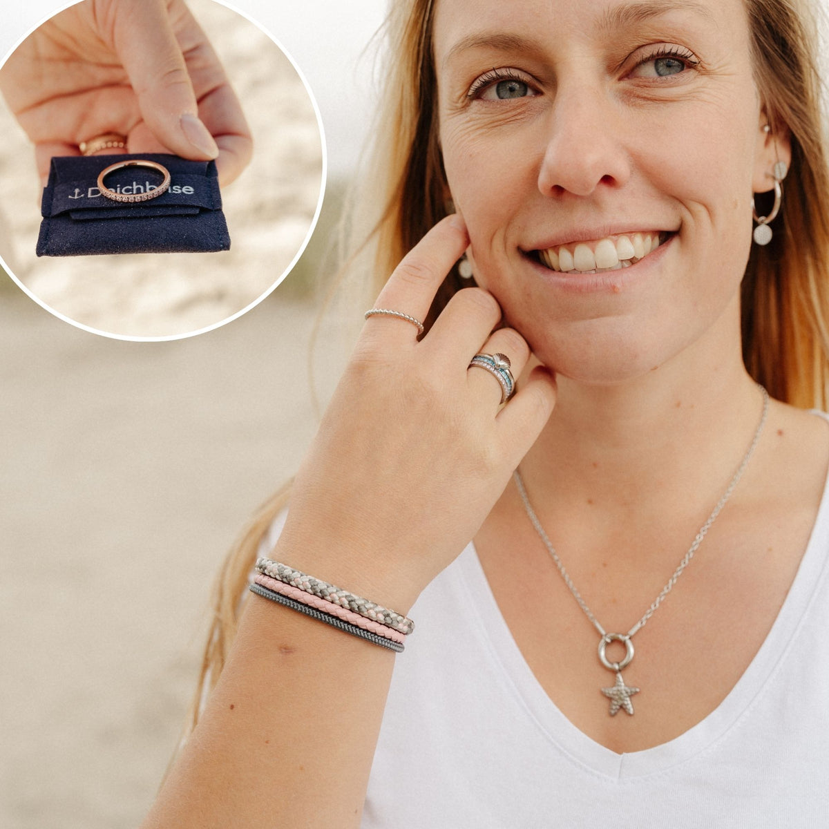 Frau am Strand mit Stapelringen und Seestern-Kette, daneben ein Ring auf einem Deichbrise-Schmuckbeutel